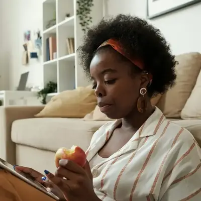 Kenyan freelancer seated at home reviewing tax details on her iPad – Zidika Consulting
