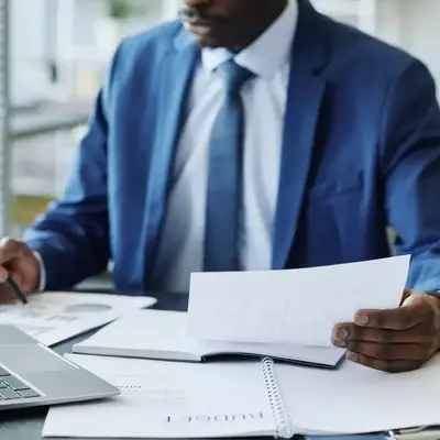 Man in Nairobi reviewing a paper next to his laptop – Zidika Consulting Kenya