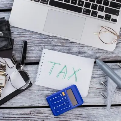 Office desk with calculator, glasses, and laptop for tax planning – Zidika Consulting Kenya
