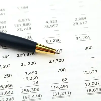 Financial report and pen for reviewing outsourced accounting in Kenya – Zidika Consulting