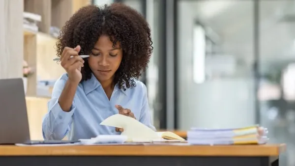 Woman reviewing notebook on withholding tax compliance at a Nairobi office – Zidika Consulting, Kenya