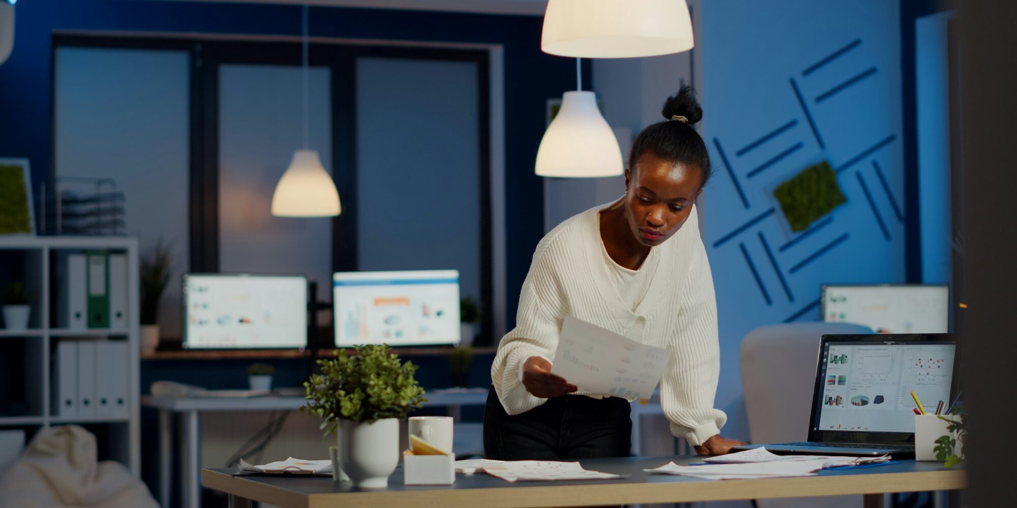 Black bookkeeper working on financial reports checking statistics graphs