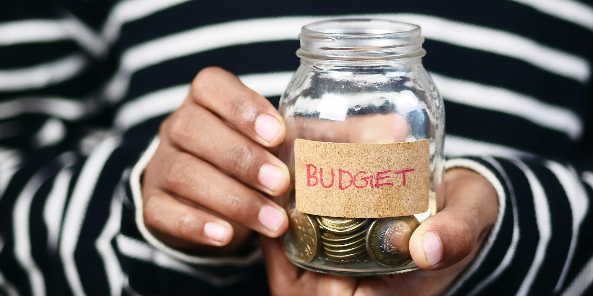 men holding a coin jar with budget text