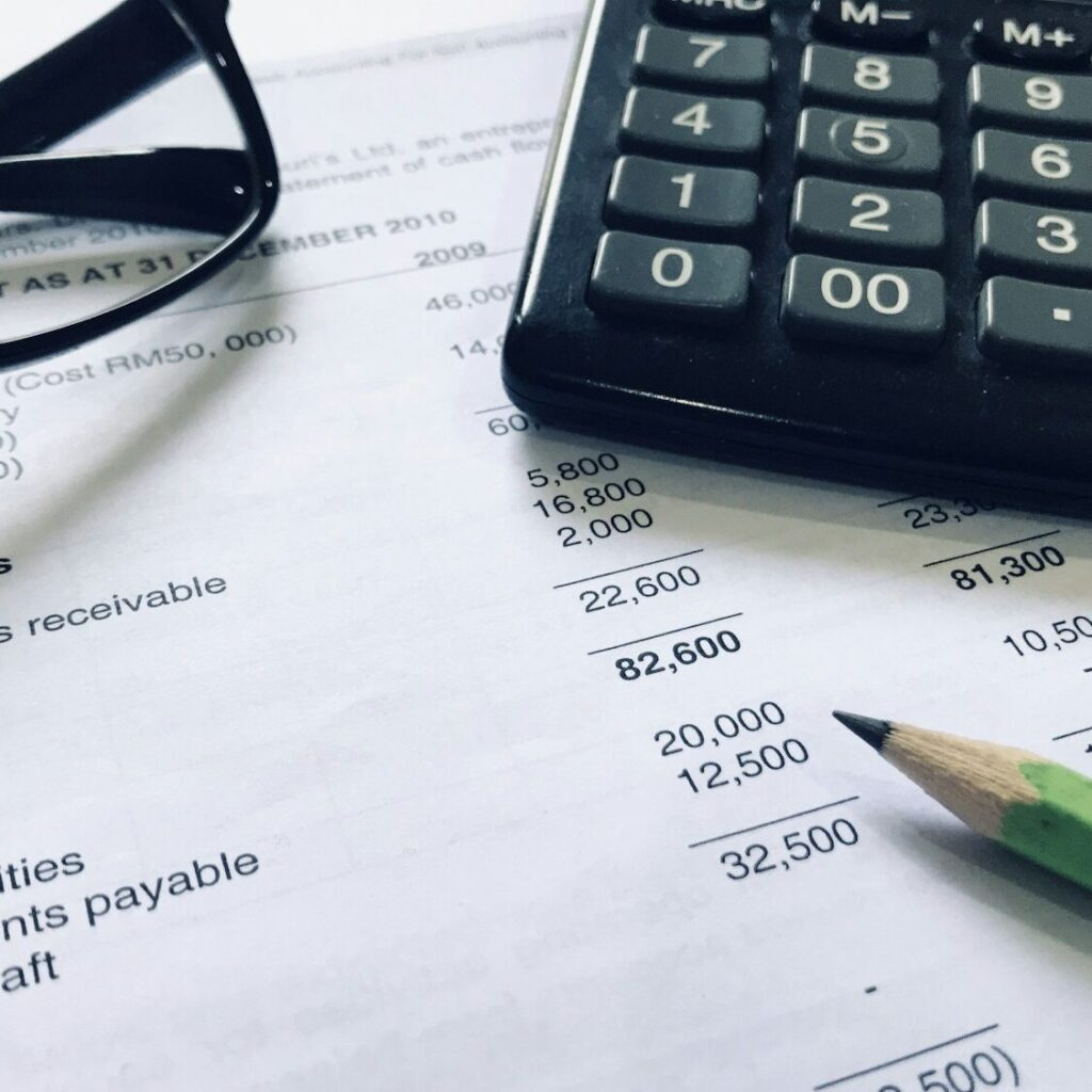 Balance sheet with calculator and glasses showing a financial review in Kenya – Zidika Consulting