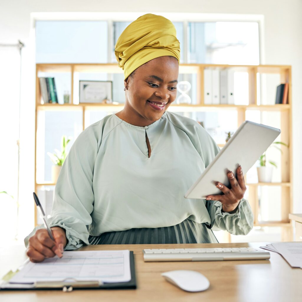Woman budgeting in a Nairobi office using notebook and desk papers – Zidika Consulting Kenya