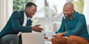 Two Nairobi businessmen discussing financial reports with support from Zidika Consulting, Kenya