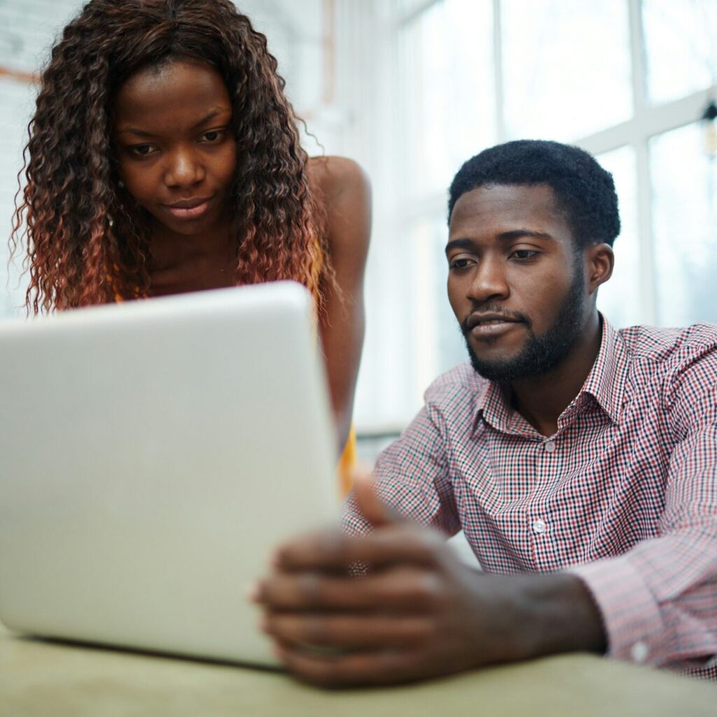 Man and woman looking at a laptop together to review statements – Zidika Consulting Kenya