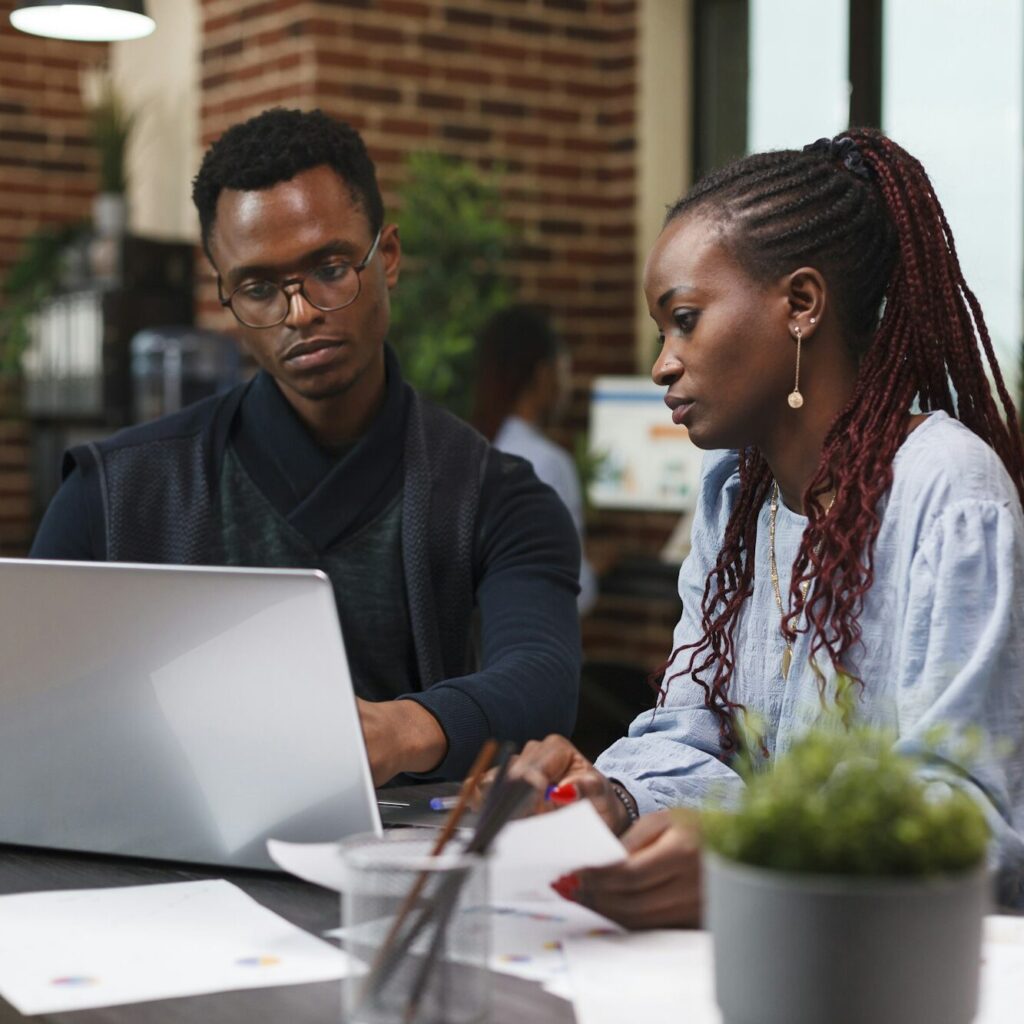 Two Kenyan entrepreneurs analyzing accounting data on a laptop – Zidika Consulting