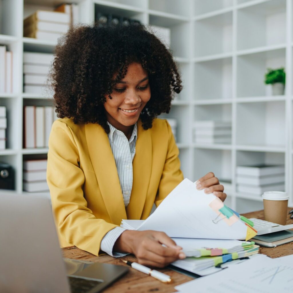 Woman smiling while reviewing VAT paperwork in a Nairobi office – Zidika Consulting