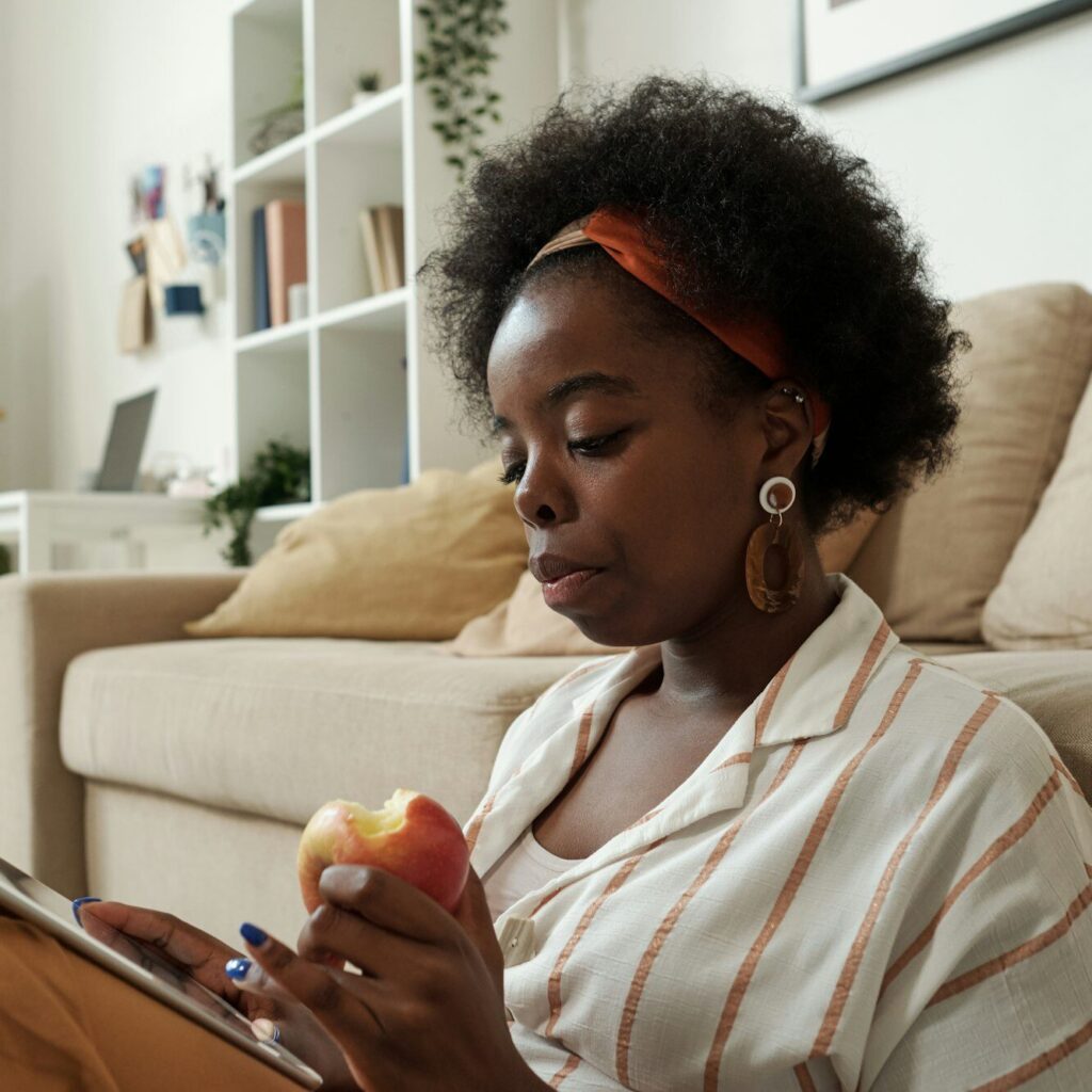 Kenyan freelancer seated at home reviewing tax details on her iPad – Zidika Consulting