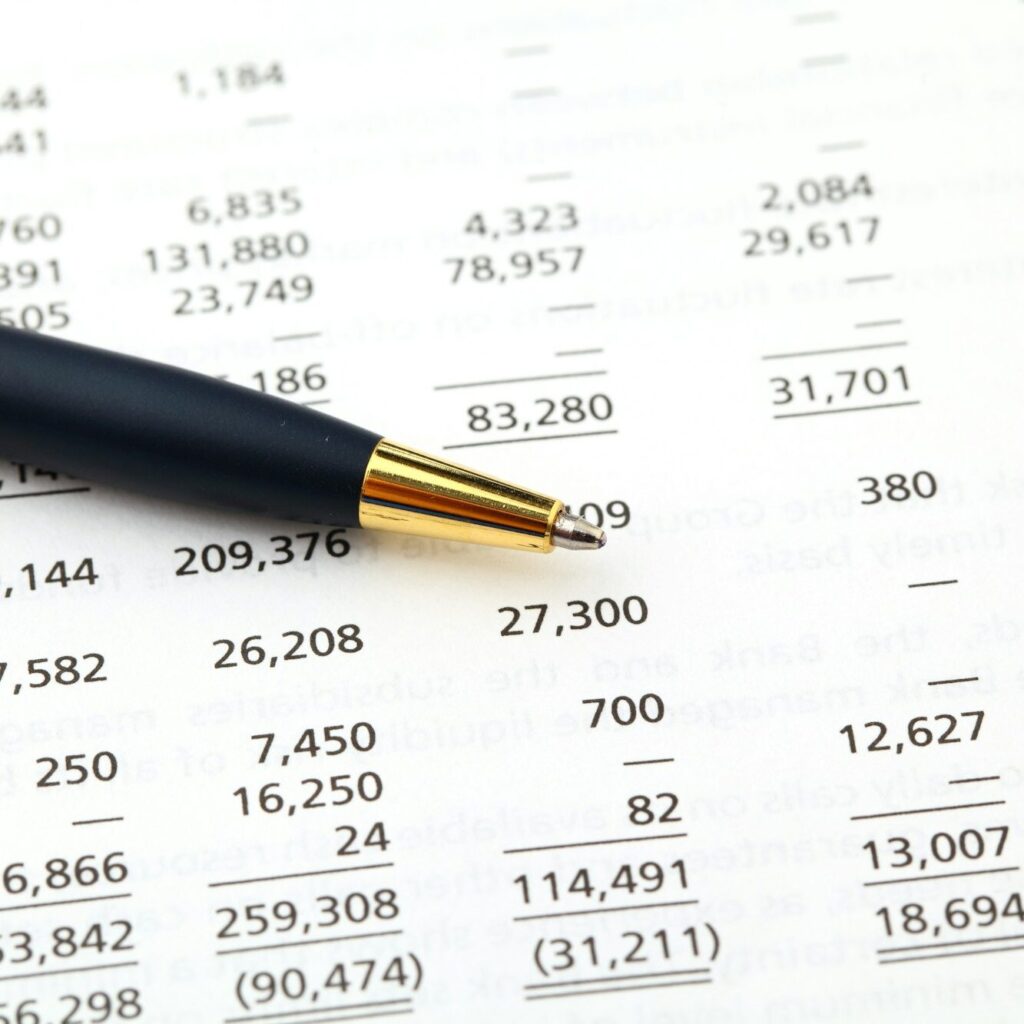 Financial report and pen for reviewing outsourced accounting in Kenya – Zidika Consulting