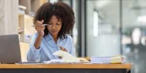 Woman reviewing notebook on withholding tax compliance at a Nairobi office – Zidika Consulting, Kenya